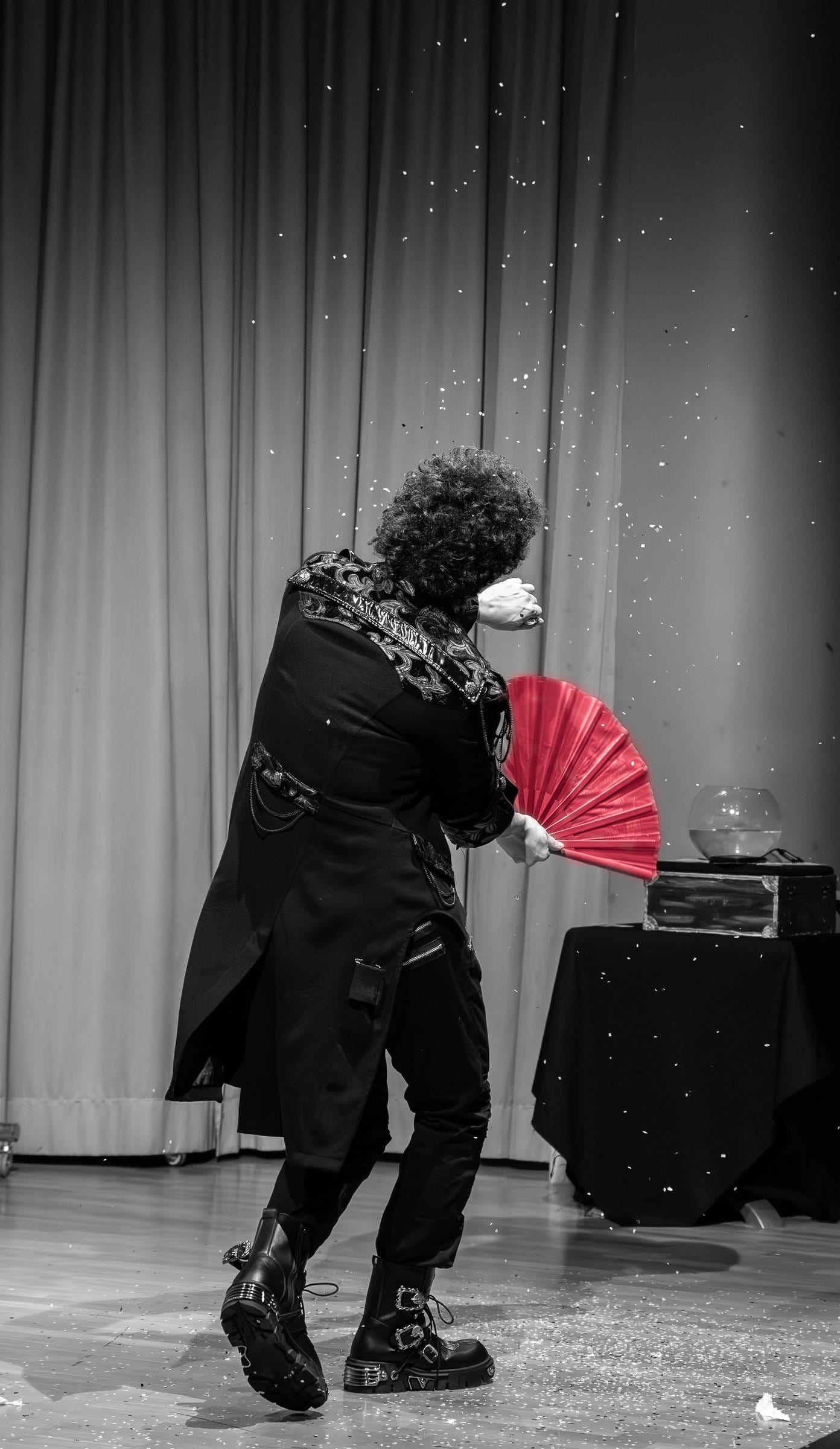 Matteo Angrisano sul palco con un ventaglio rosso, fra coriandoli d'argento